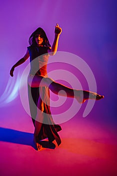 Modern teen contemporary dancer poses in front of the studio background.