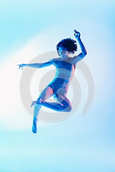 Modern teen contemporary dancer poses in front of the studio background.