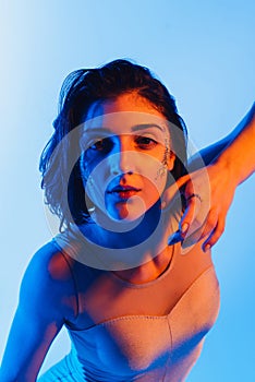 Modern teen contemporary dancer poses in front of the studio background.