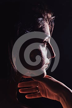 Modern teen contemporary dancer poses in front of the studio black background.