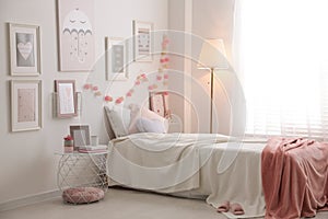 Modern teenager`s room with comfortable bed and beautiful pictures