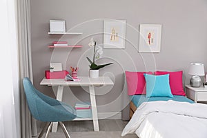 Modern teenager`s room interior with comfortable bed and workplace