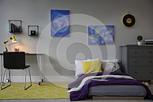 Modern teenager`s room interior with comfortable bed, workplace and stylish design elements