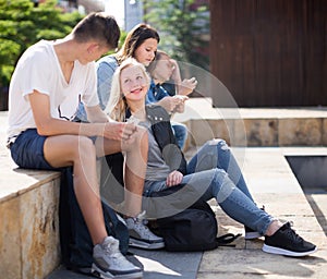 Modern teenagers communicate in schoolyard