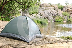 Modern  tent on riverbank in wilderness. Space for text