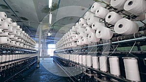 Modern textile factory. Industrial unit with plenty of revolving sewing reels