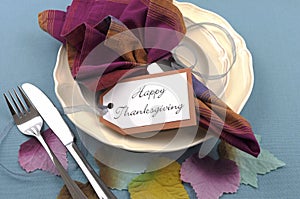 Modern Thanksgiving dining table place setting with autumn leaves