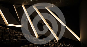Modern theater interior with angular, geometric wall designs featuring illuminated