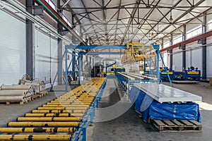 Modern thermal insulation sandwich panel production line. Machine tools, roller conveyor and overhead crane in workshop