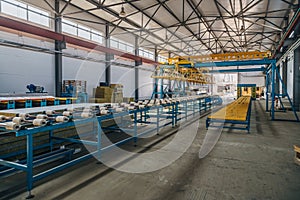 Modern thermal insulation sandwich panel production line. Machine tools, roller conveyor and overhead crane in workshop