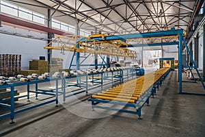 Modern thermal insulation sandwich panel production line. Machine tools, roller conveyor and overhead crane in workshop