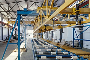 Modern thermal insulation sandwich panel production line. Machine tools, roller conveyor in workshop