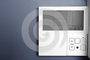 Modern thermostat on grey wall with space for text