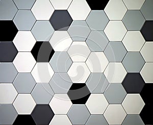 Modern tiled floor with hexagonal tiles. Colors are black,white, light and dark gray randomly arranged