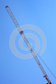 Modern tower crane against blue sky.