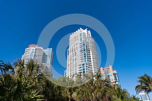 Modern towerblocks high-rise buildings architecture and palms on blue sky in South Beach, USA