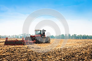 Modern tractor in the field with complex for the plowing of soil.