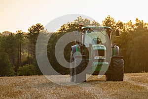 Modern tractor on the field after harvest