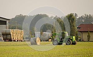 Modern tractor moving hay bales