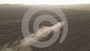 Modern tractor working plowing and sowing on the agricultural field - aerial view - high top view
