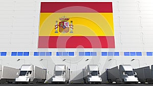 Modern trailer trucks load or unload at warehouse bays with flag of SPAIN. Spanish logistics related conceptual 3D