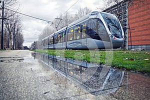 Modern tram reflecting in puddle n Toulouse, France