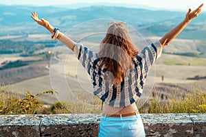 Modern traveller woman rejoicing against scenery of Tuscany
