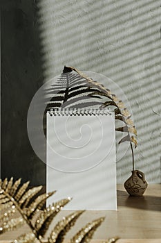 Modern trend home decor mock-up with shadows. Fall autumn minimal mock up with open empty note pad, golden dry leaves and candle