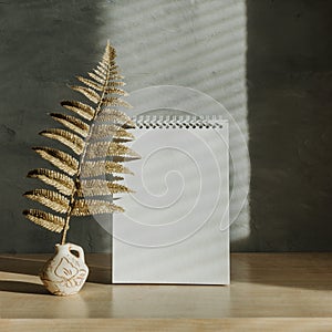 Modern trend home decor mockup with shadows and golden leaves. Fall autumn minimal mock up with open empty note pad, golden fern