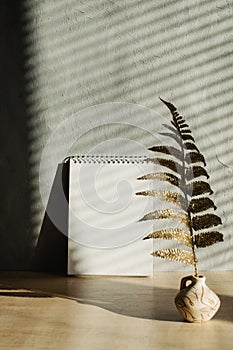 Modern trend mockup with shadows and hard light. Fall autumn minimal mock up with open empty note pad, golden dry leaves and