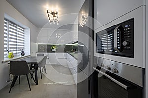 White modern kitchen with granite counter top and marble floor