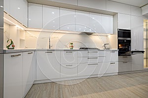 Modern trendy white luxury kitchen in a studio apartment interior
