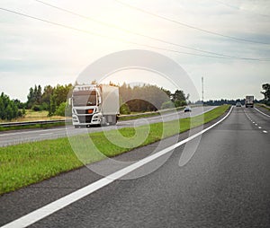 A modern truck with a semi-trailer transports humanitarian aid to another country on a highway. Cargo transportation and