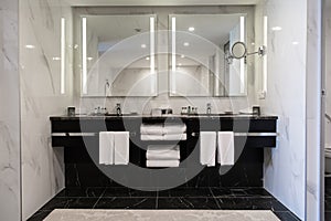 Modern twin bathroom with sinks, mirrors and towels photo