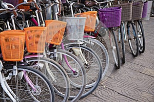 Modern urban bicycles with baskets. Bikes for rent in asian city. Urban transport of summer town.