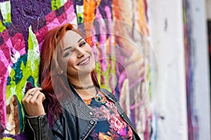 Modern urban girl in front of graffiti wall