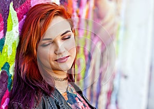 Modern urban girl in front of graffiti wall