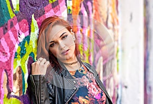 Modern urban girl in front of graffiti wall