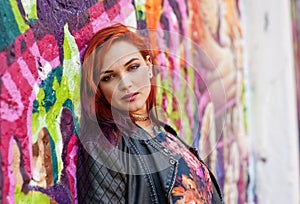 Modern urban girl in front of graffiti wall