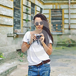 Modern urban girl with vintage photo camera outdoor