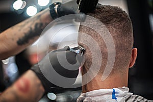 Modern urban hairdresser cut hair with hair trimmer in professional hairdressing salon