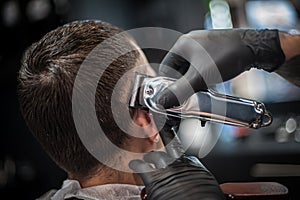 Modern urban hairdresser cut hair with hair trimmer in professional hairdressing salon