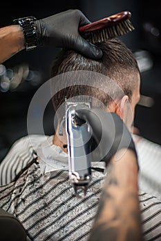 Modern urban hairdresser cut hair with hair trimmer in professional hairdressing salon