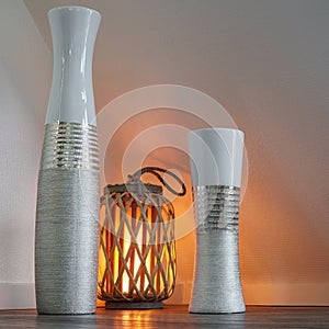 Modern vases in the living area, illuminated by a cozy wooden lamp