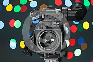 Modern video camera against blurred lights