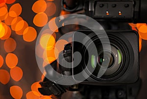 Modern video camera against blurred lights