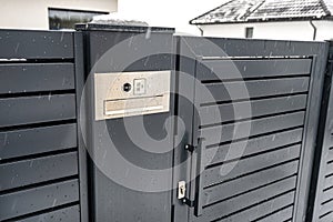 A modern videophone with a letterbox and a wireless card reader, mounted in panel fence in anthracite color, visible wicket.