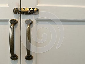 Modern vintage style door handle and slide lock on white natural wooden door, white door space on the right with lock and handle