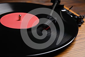 Modern vinyl record player with disc on table, closeup