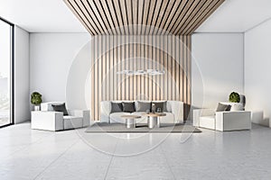 Modern waiting area in a luxuty hotel lobby, with sofa, white walls and concrete floor and big window